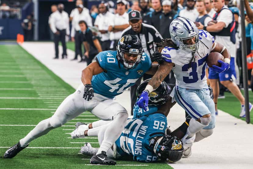 Dallas Cowboys running back JaQuan Hardy, 37, gets pushed out of the sideline by...