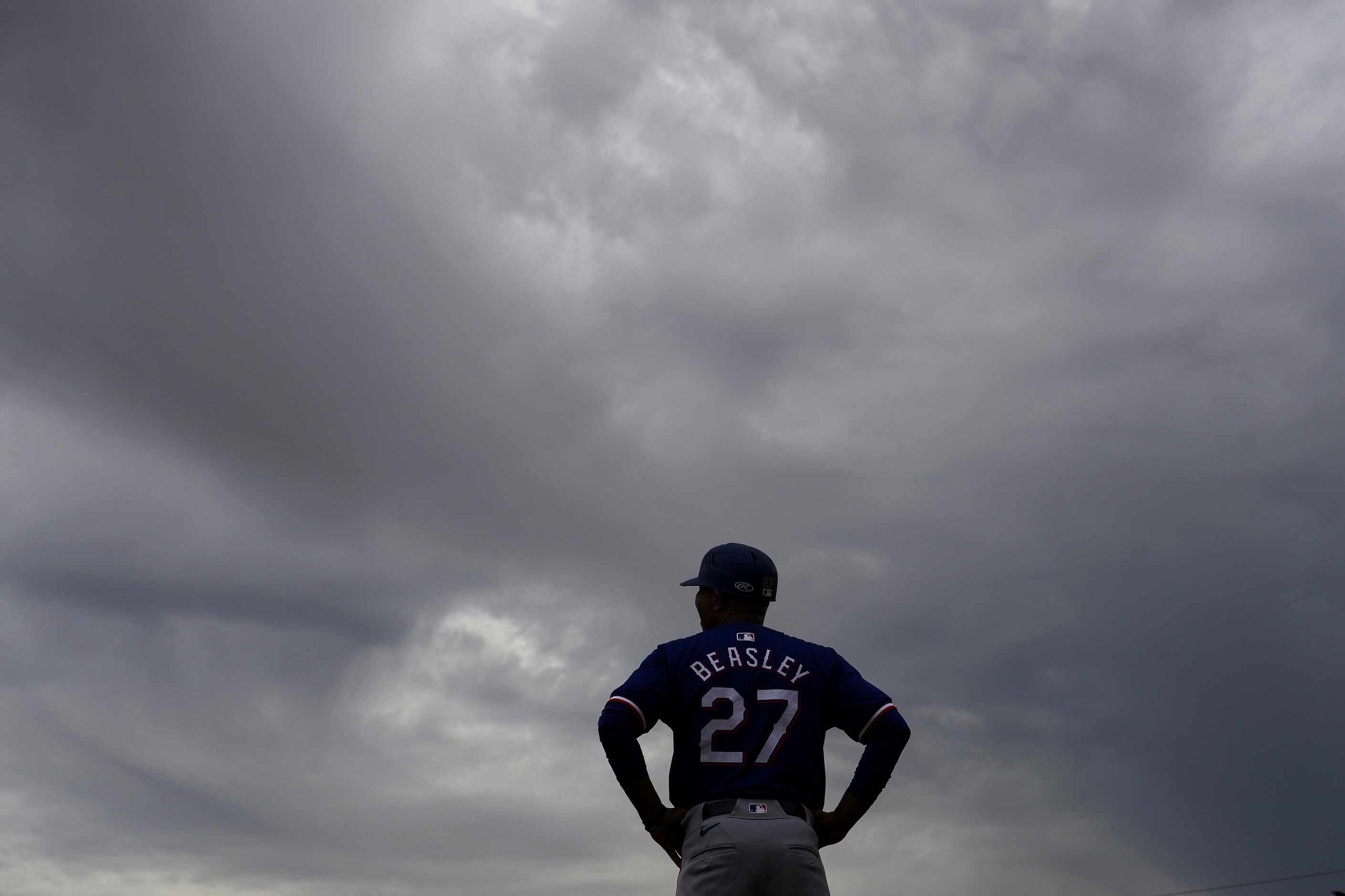 Texas Rangers third base coach Tony Beasley looks out on the field during the third inning...