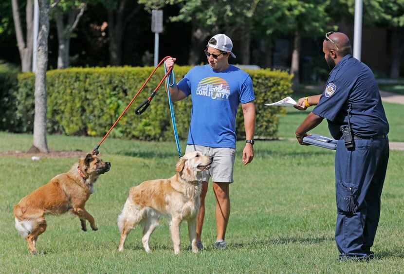 Dallas Animal Services field officer Allen Davis (right) handed out educational information...