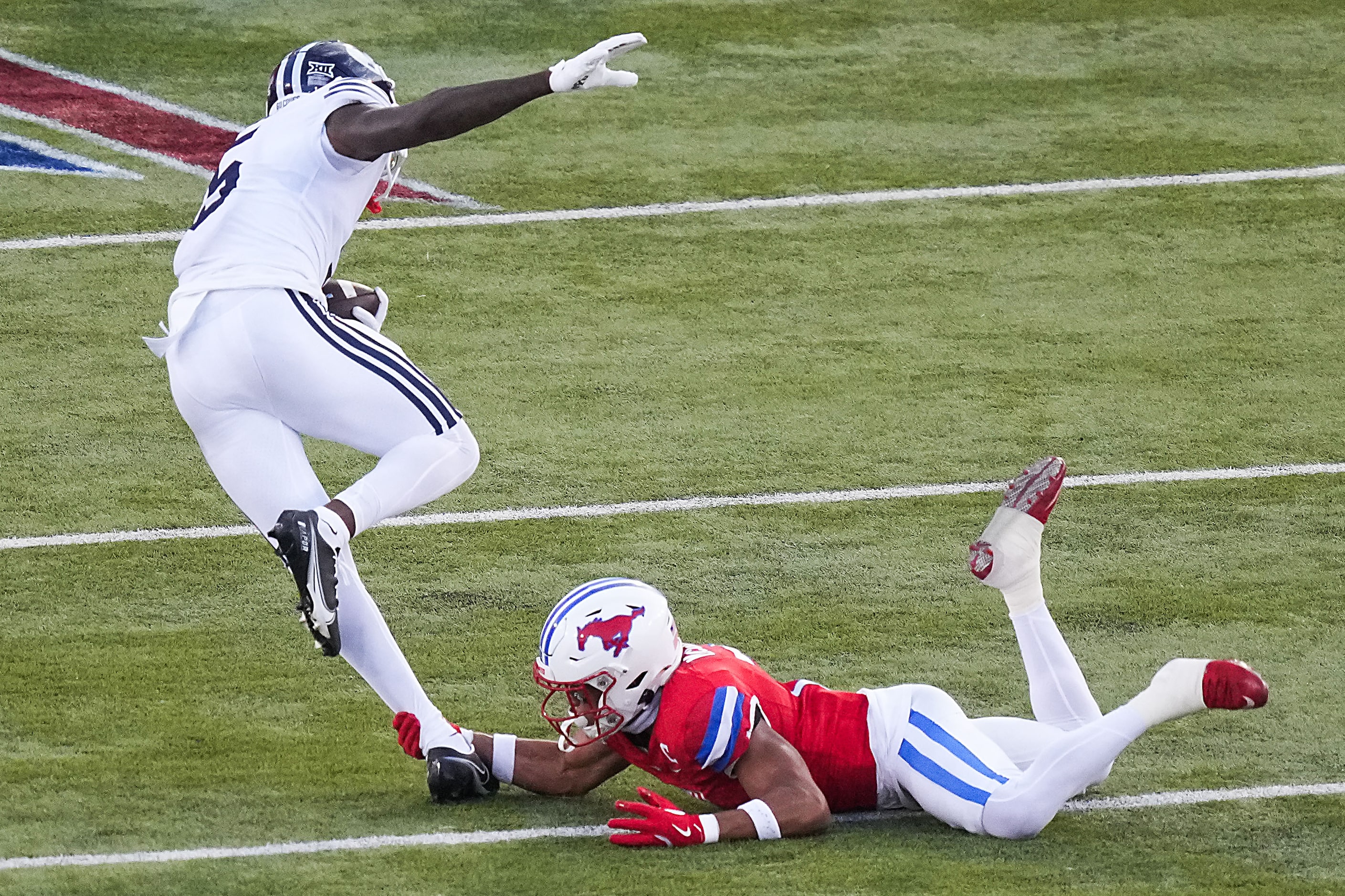 BYU wide receiver Darius Lassiter (5) is tripped up by SMU safety Jonathan McGill (2) during...