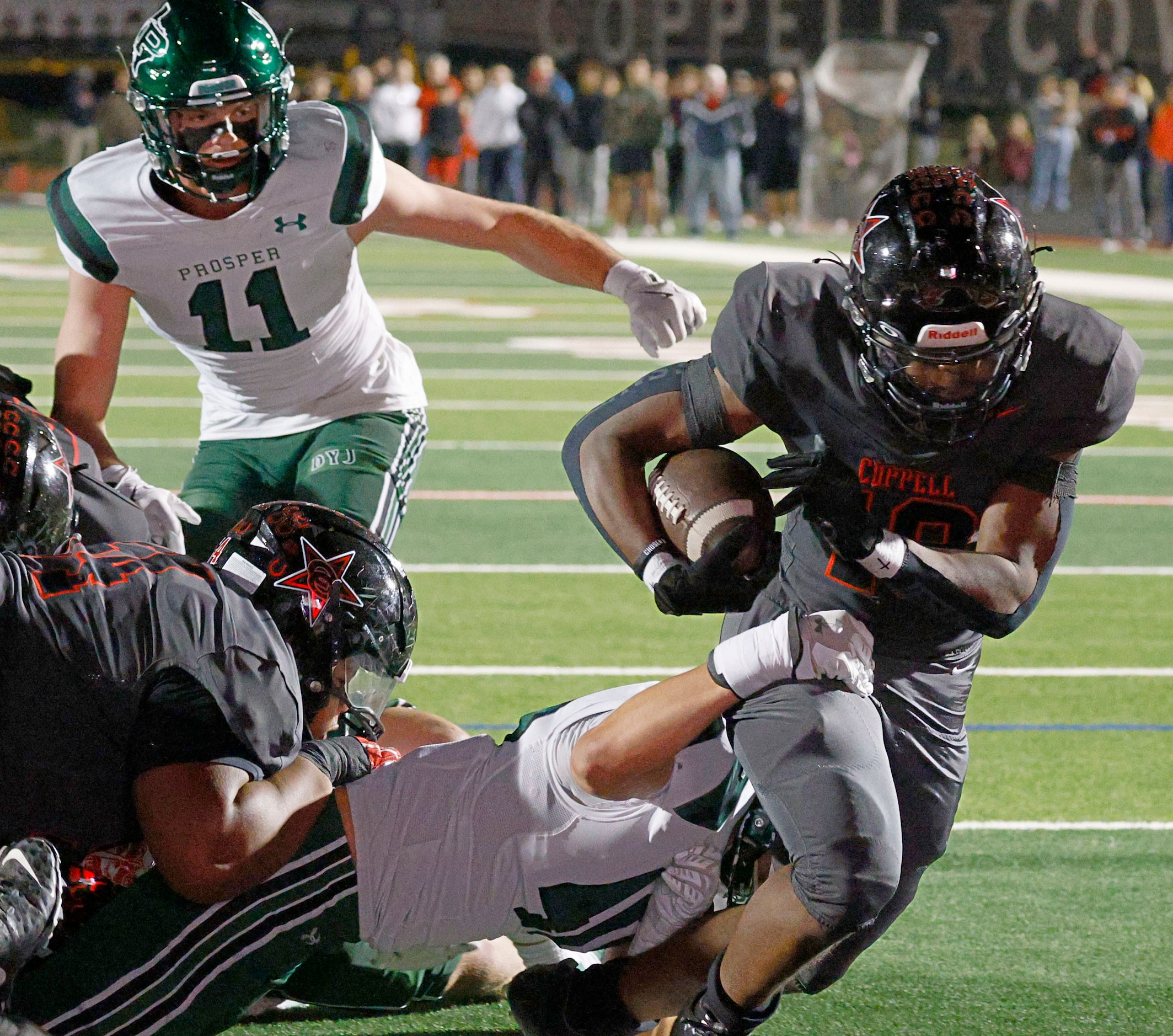 Coppell's Josh Lock (18), right, scores a touchdown as Prosper's Cade Smallwood (40), bottom...