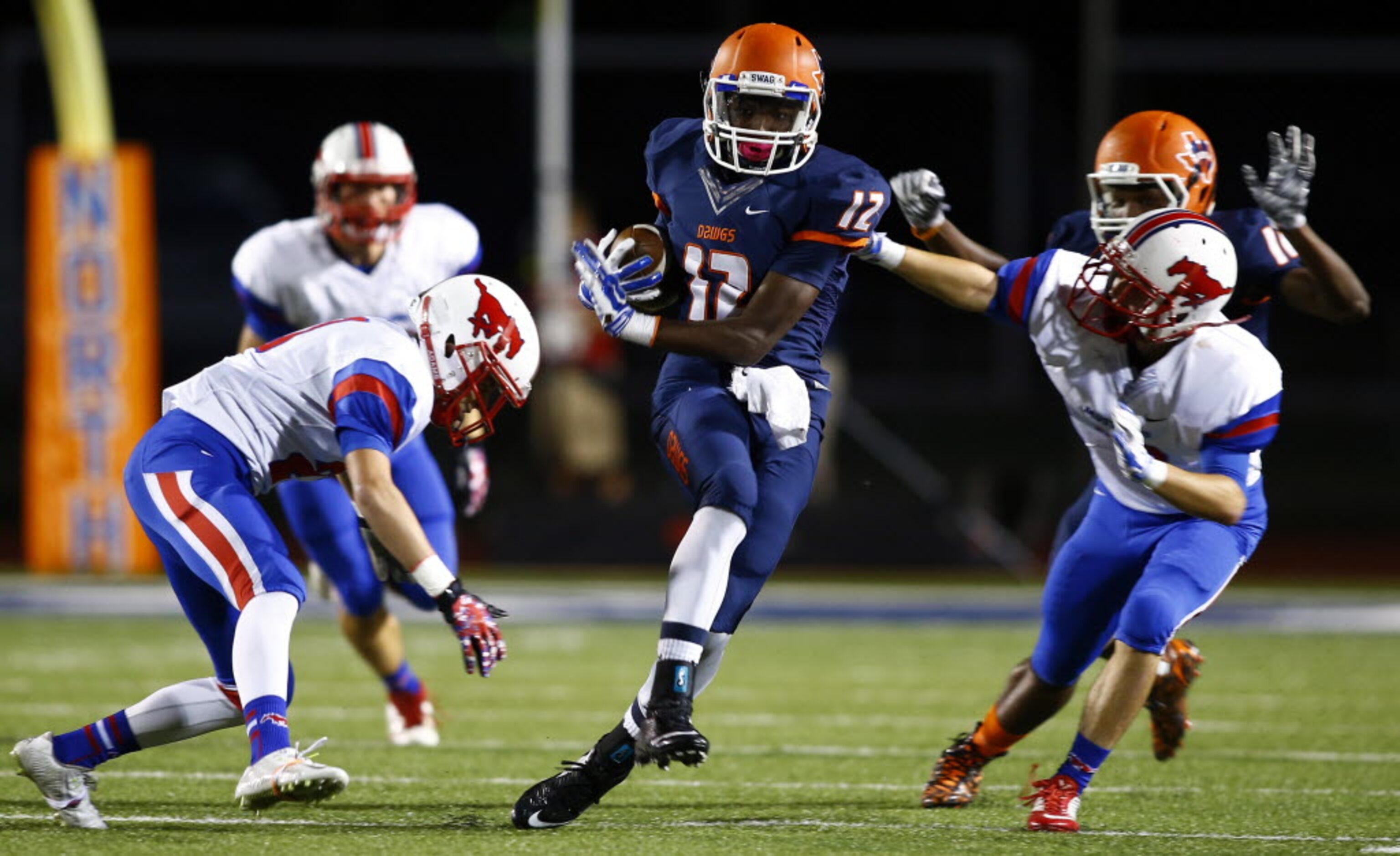 TXHSFB McKinney North wide receiver Miguel Hudson (12) runs between Richardson Pearce...