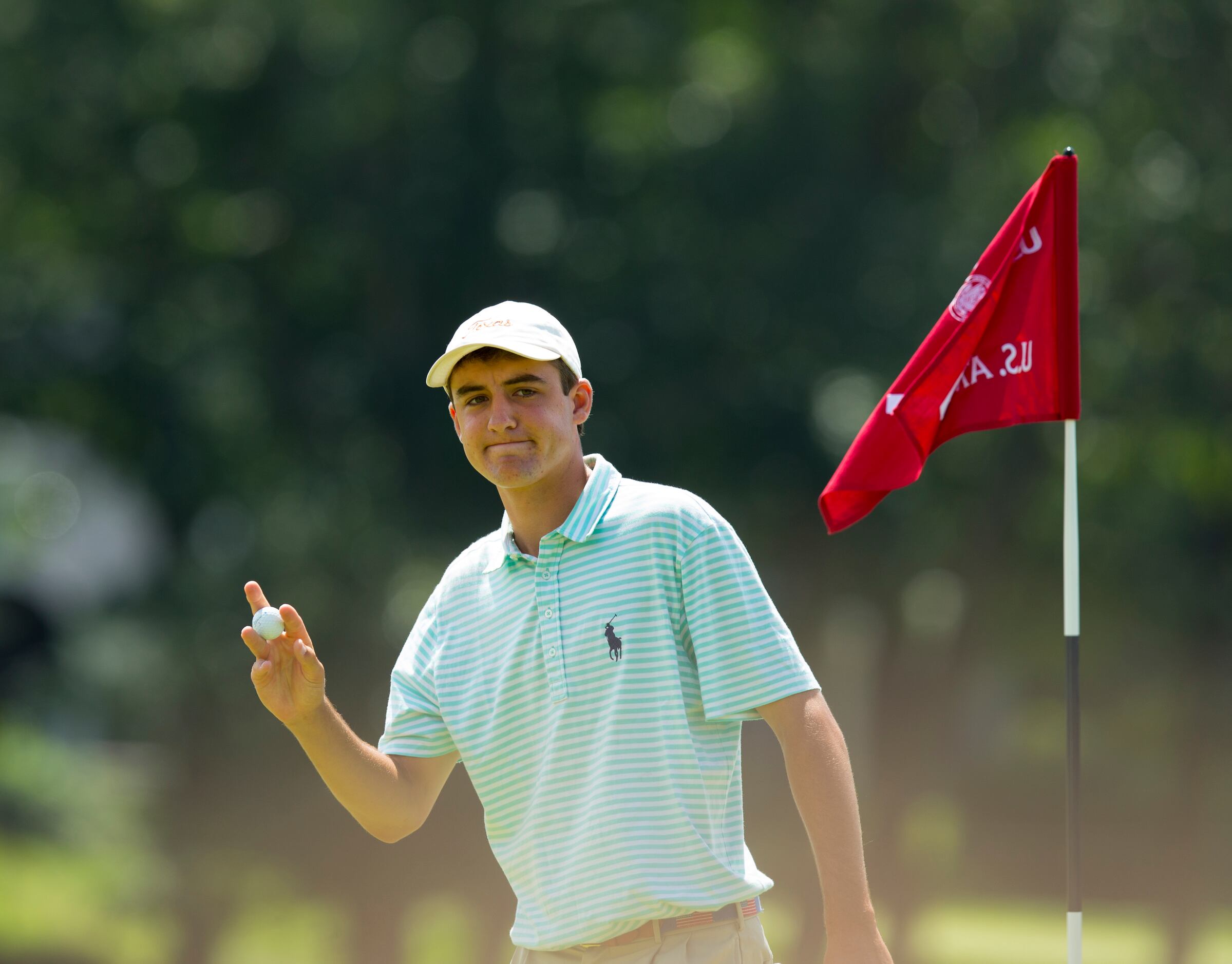 Scottie Scheffler waves after making a hole in one on the seventh hole during the...