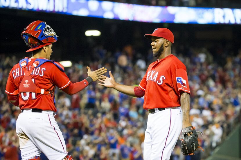 Texas Rangers relief pitcher Neftali Feliz celebrates with catcher Robinson Chirinos after...