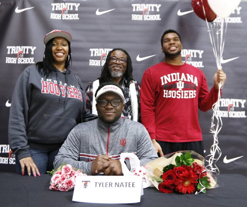 Euless Trinity quarterback Tyler Natee, front center, pose with family after signing his...