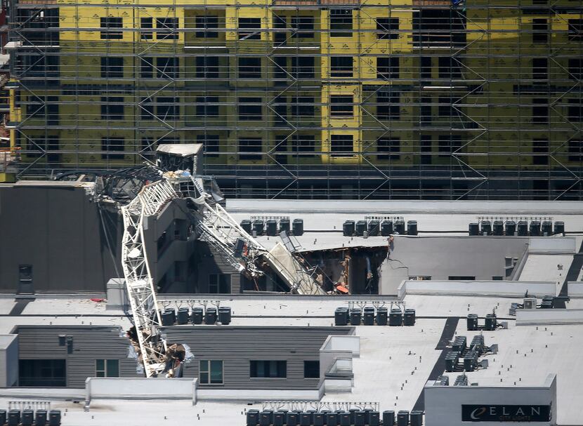 A collapsed tower crane operated by Bigge Crane and Rigging lies where it fell on top of the...