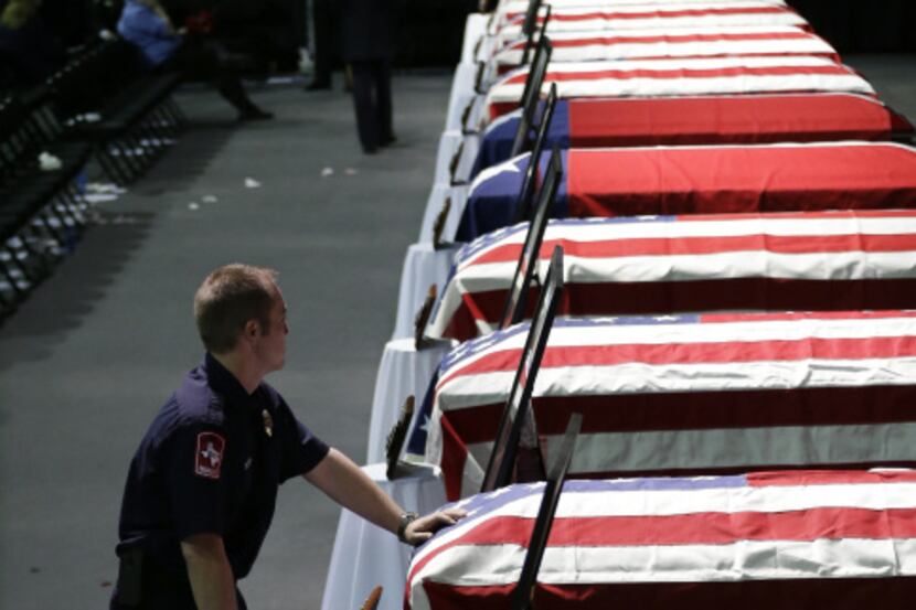 Paramedic Bryce Reed leaned on the casket of firefighter Cyrus Reed after a service where he...