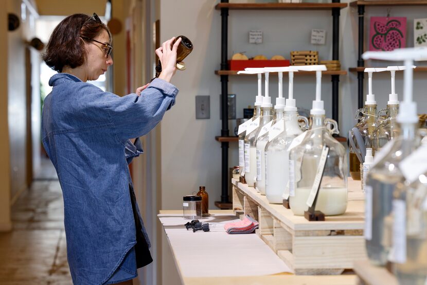 Customer Kattie Mokhtarzadeh refills her bottles with products at Usefull, a fillable...