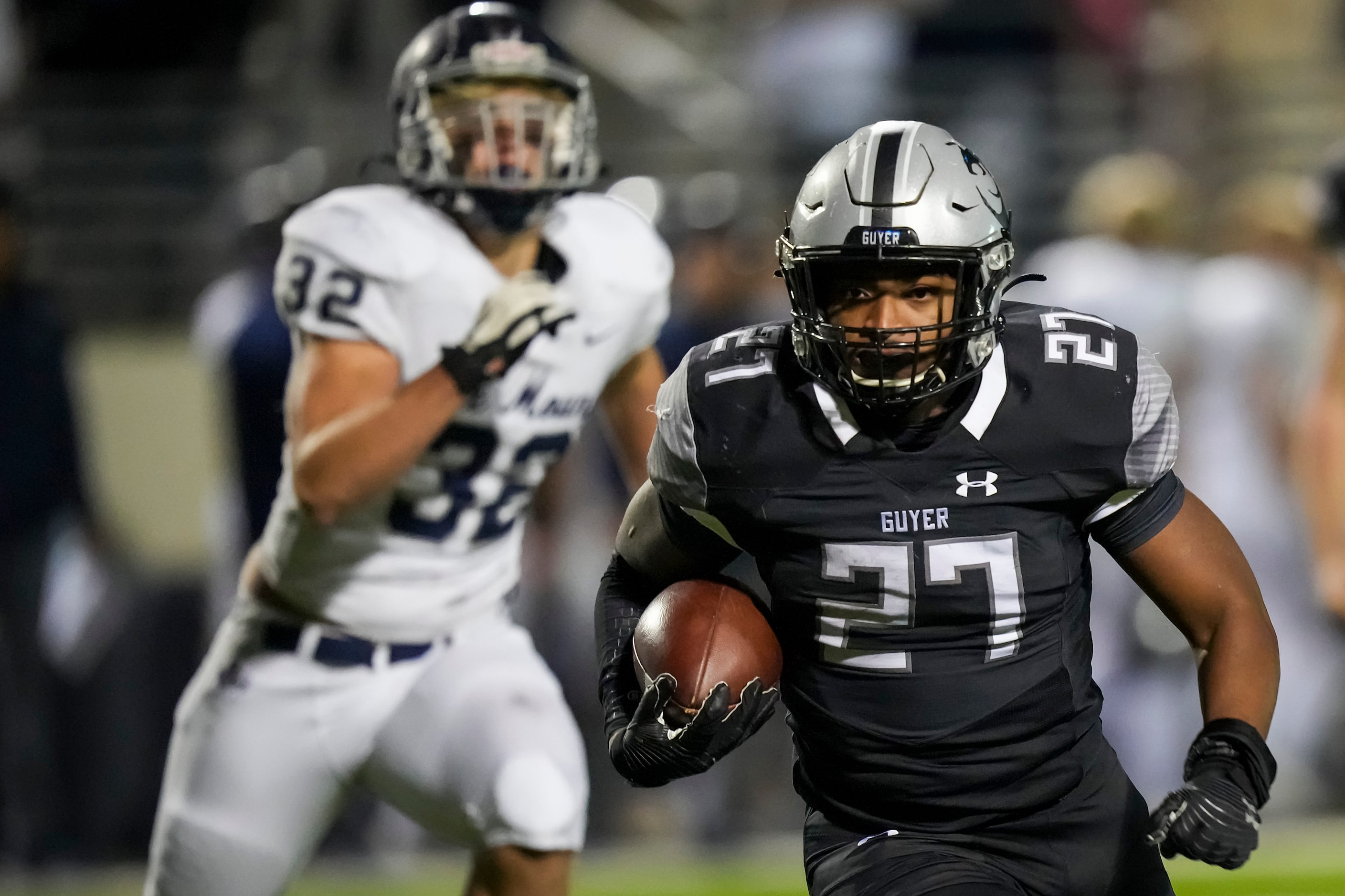 Denton Guyer running back Byron Phillips (27) runs past Flower Mound defensive end Caleb...