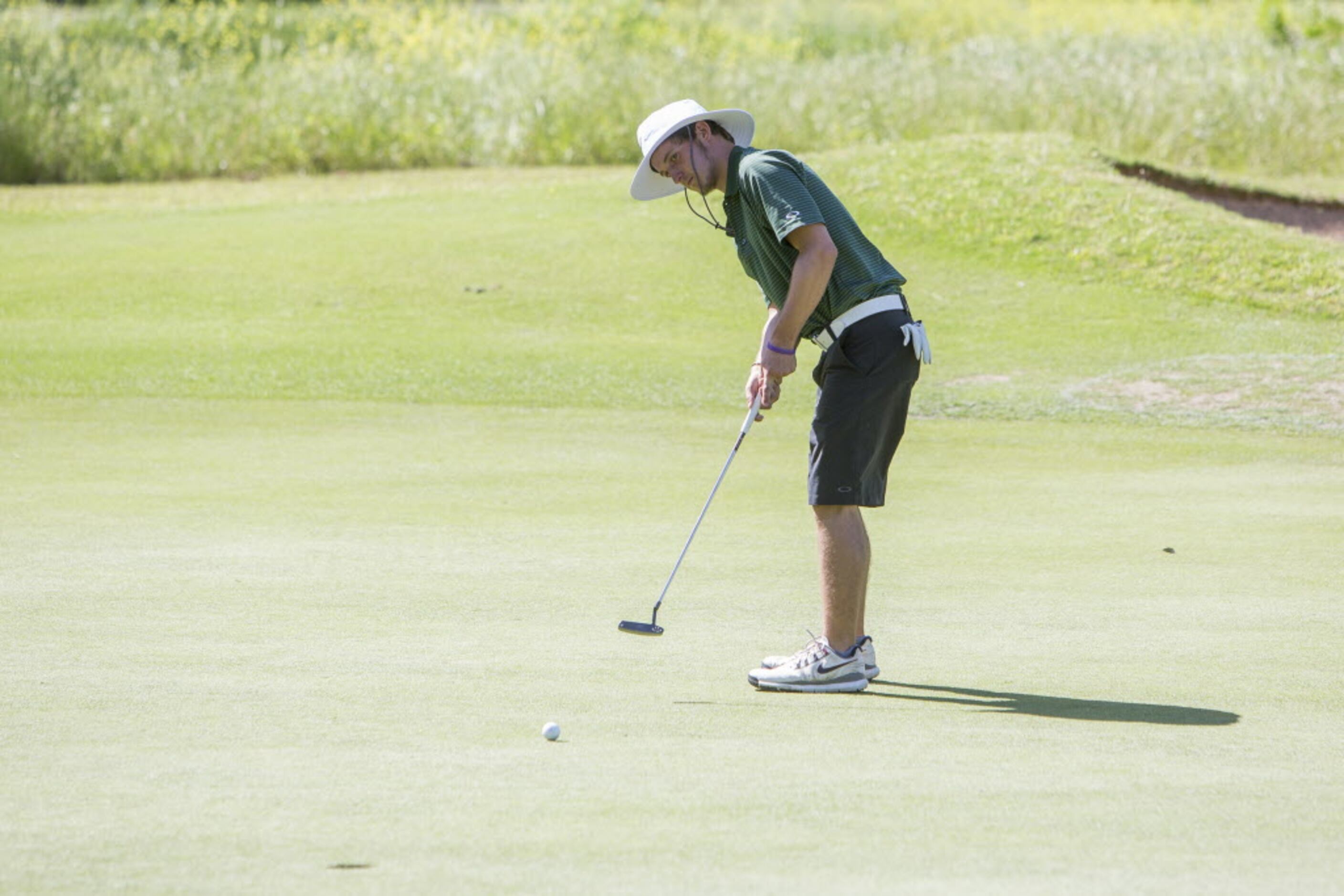 Southlake Carroll junior Hunter Glenn takes a long putt on the first green at the UIL 5A...