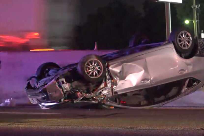 A car lies on its roof after a wreck on North Stemmons Freeway Wednesday night in Dallas.