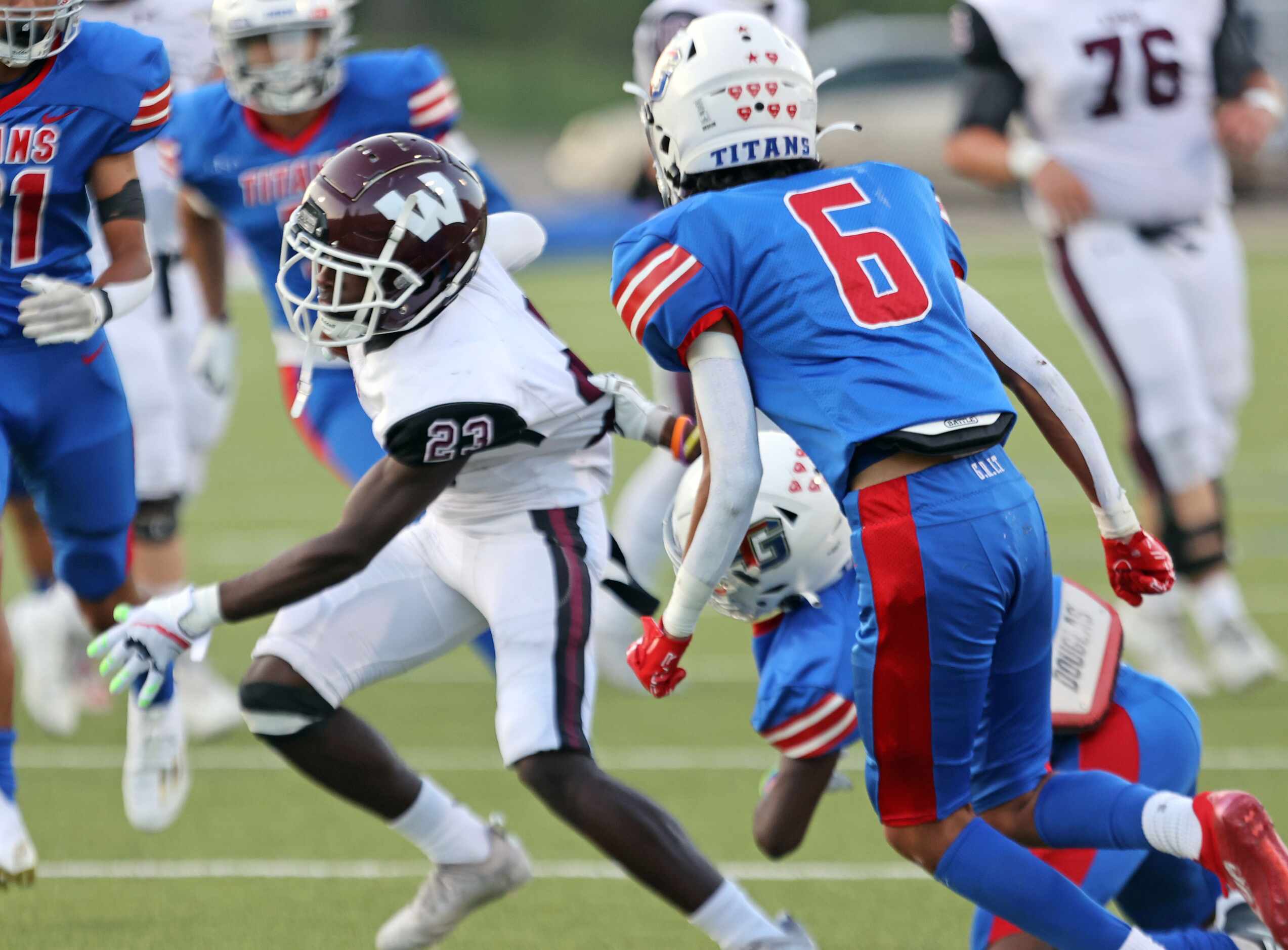 Wylie High Martaveion Sanders (23) drags a South Garland High defender along with him, as he...