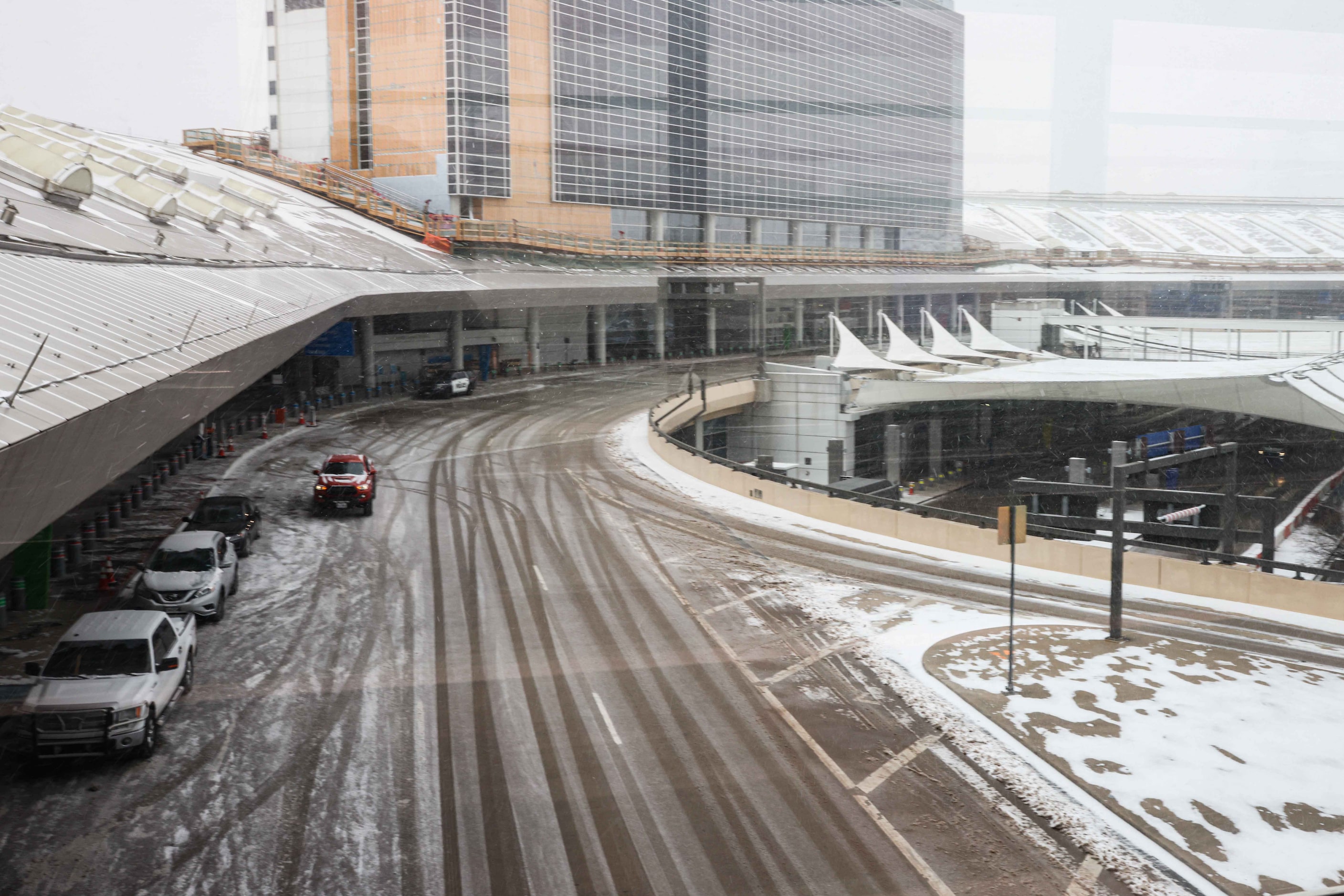 Snow, ice decend over DFW International Airport as American cancel hundreds of flights in...