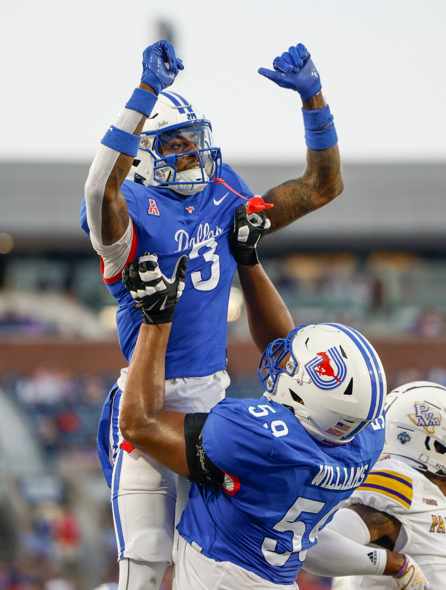 SMU offensive lineman PJ Williams (59) lifts SMU wide receiver Romello Brinson (3) after...