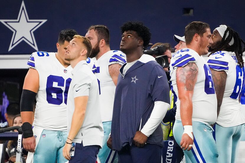 Dallas Cowboys offensive tackle Tyler Smith (center) watches from the sidelines during the...