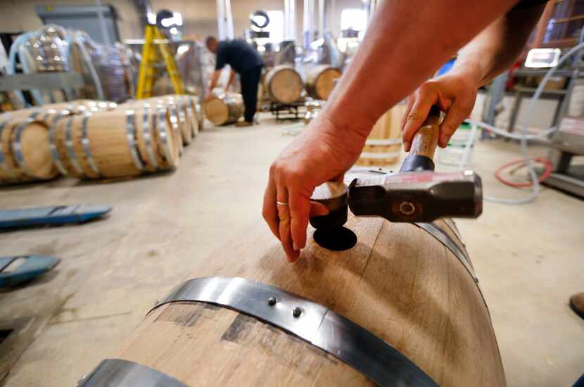 Distiller Brad Berven taps a white oak barrel to be filled with single malt whiskey at Acre...