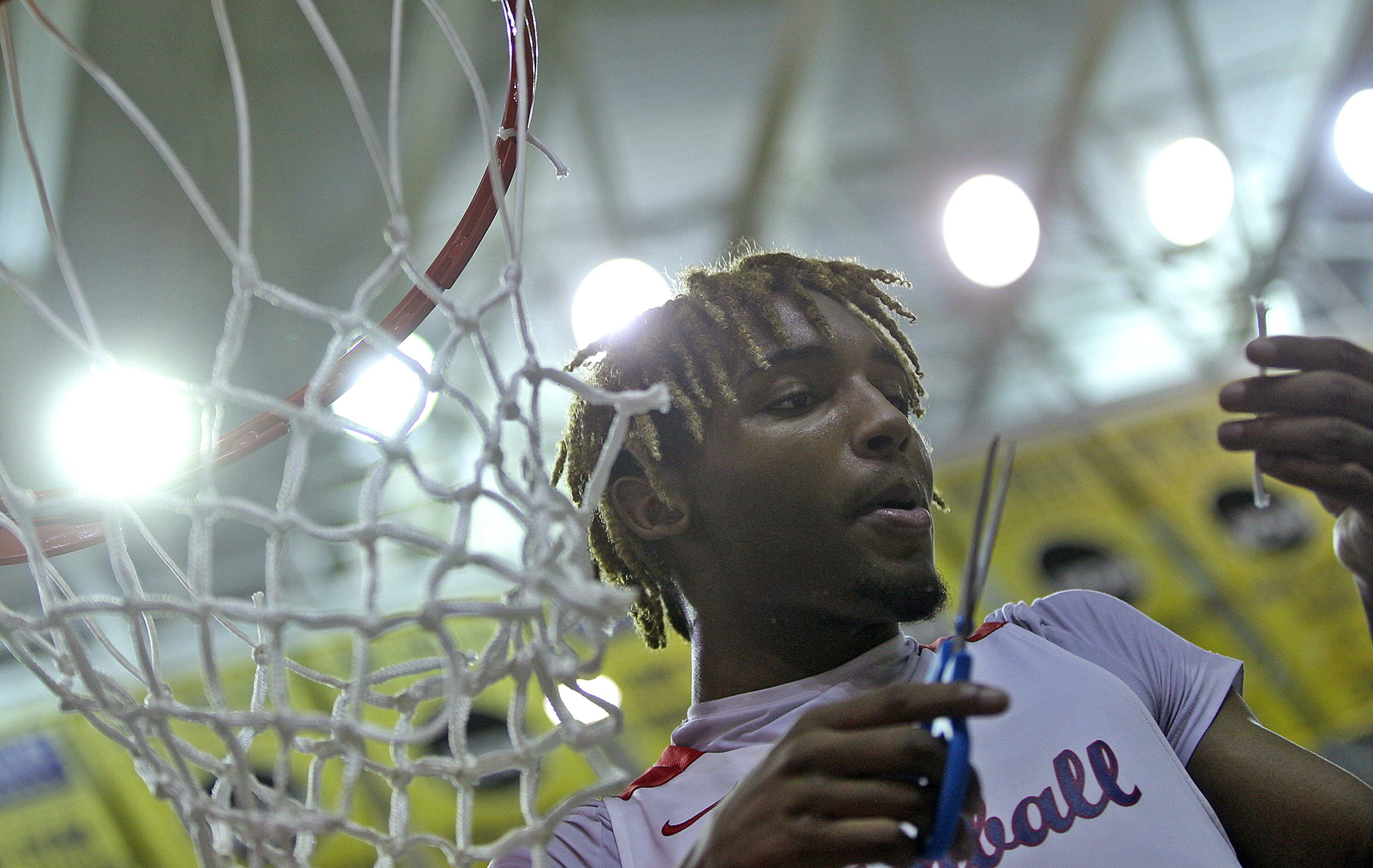 Arterio Morris cuts down part of the net after Kimball defeated Amarillo during the UIL 5A...