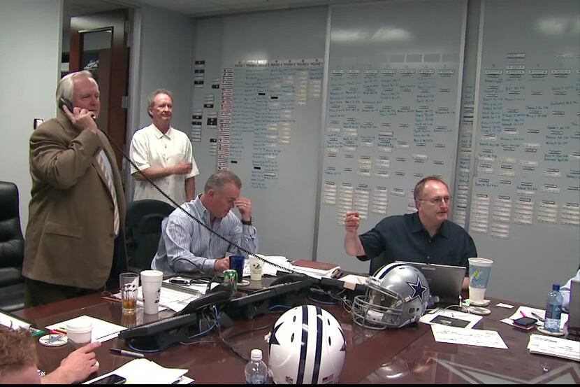 The Cowboys work during the draft, with their board in the backdrop during the 2010 draft.