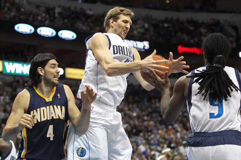 Dallas Mavericks power forward Dirk Nowitzki fights for a rebound alongside Indiana Pacers...