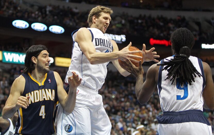 Dallas Mavericks power forward Dirk Nowitzki fights for a rebound alongside Indiana Pacers...