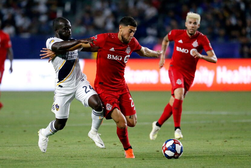 LA Galaxy's Emmanuel Boateng, left, defends against Toronto FC midfielder Jonathan Osorio,...