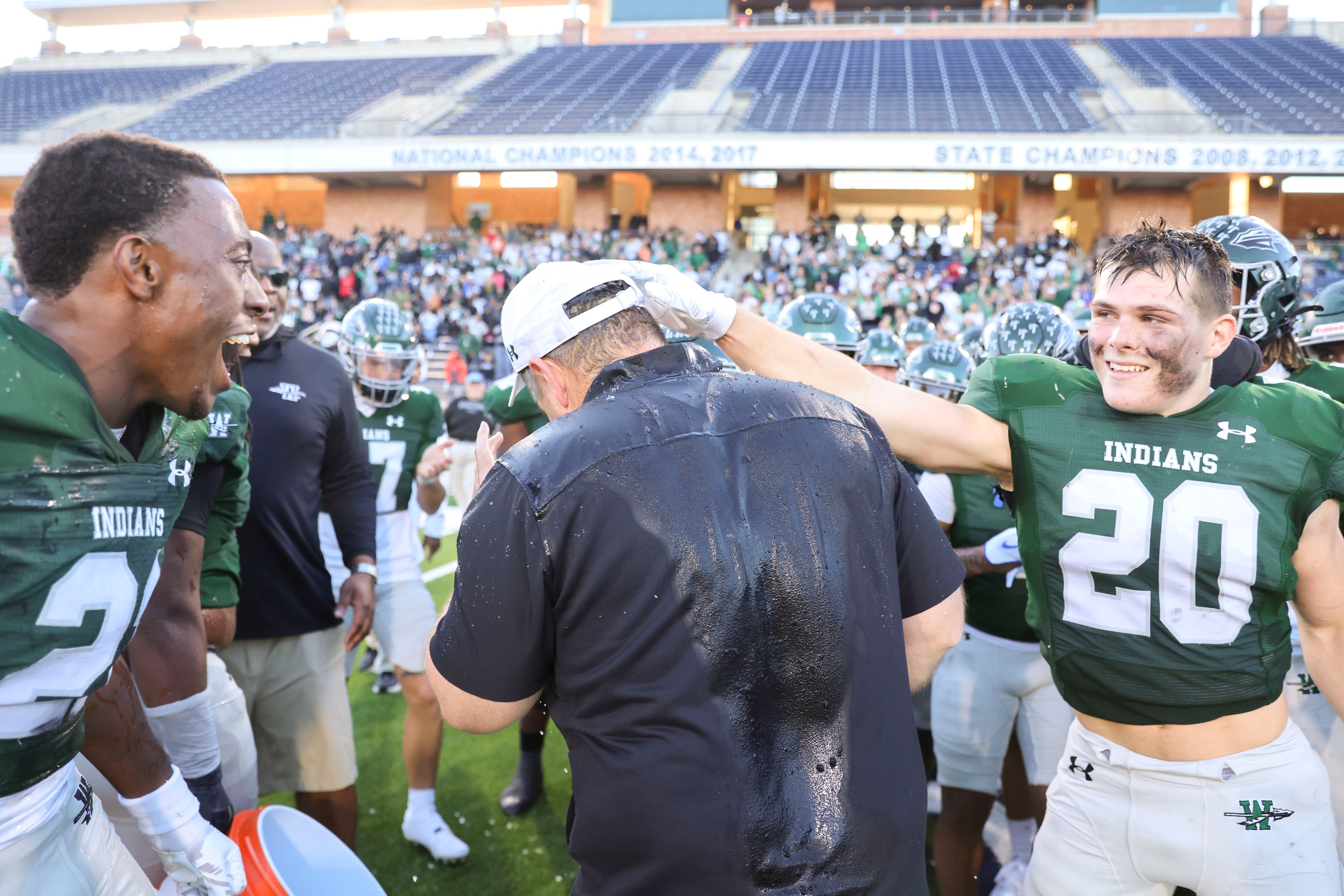 Waxahachie High football head coach Shane Tolleson is greeted by players following their win...