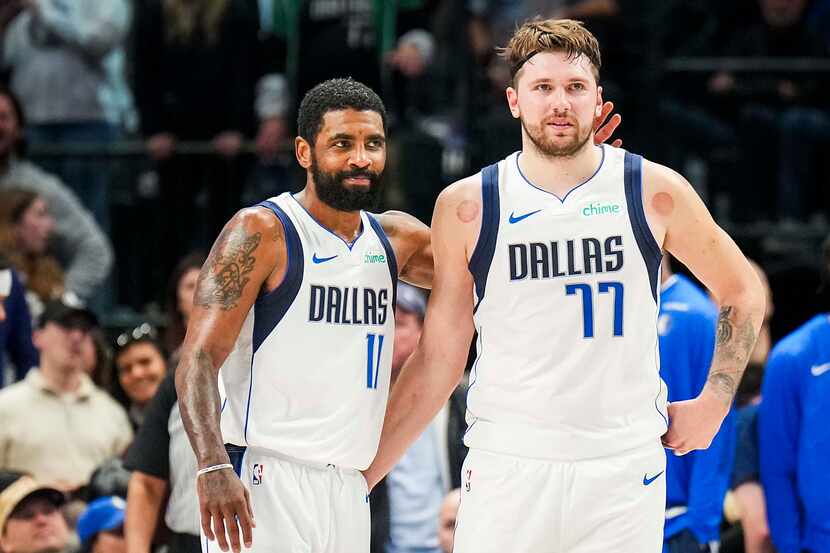 Dallas Mavericks guard Kyrie Irving (11) hugs guard Luka Doncic (77) during the second half...