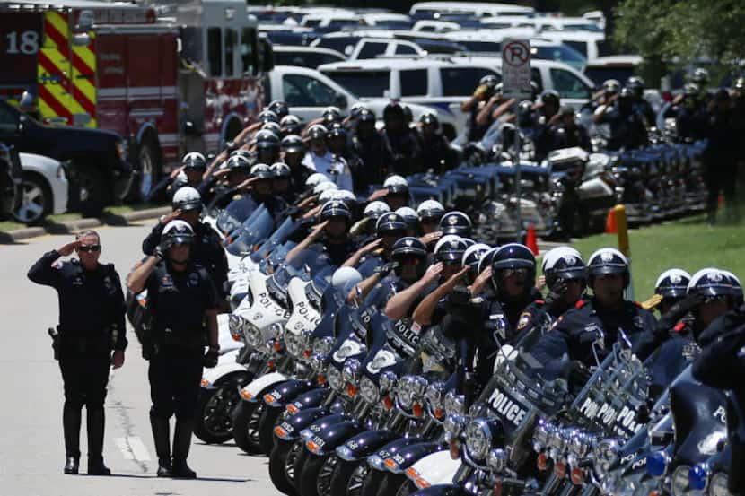 Law enforcement salute as the coffin of Dallas police sergeant Michael Smith is moved into a...