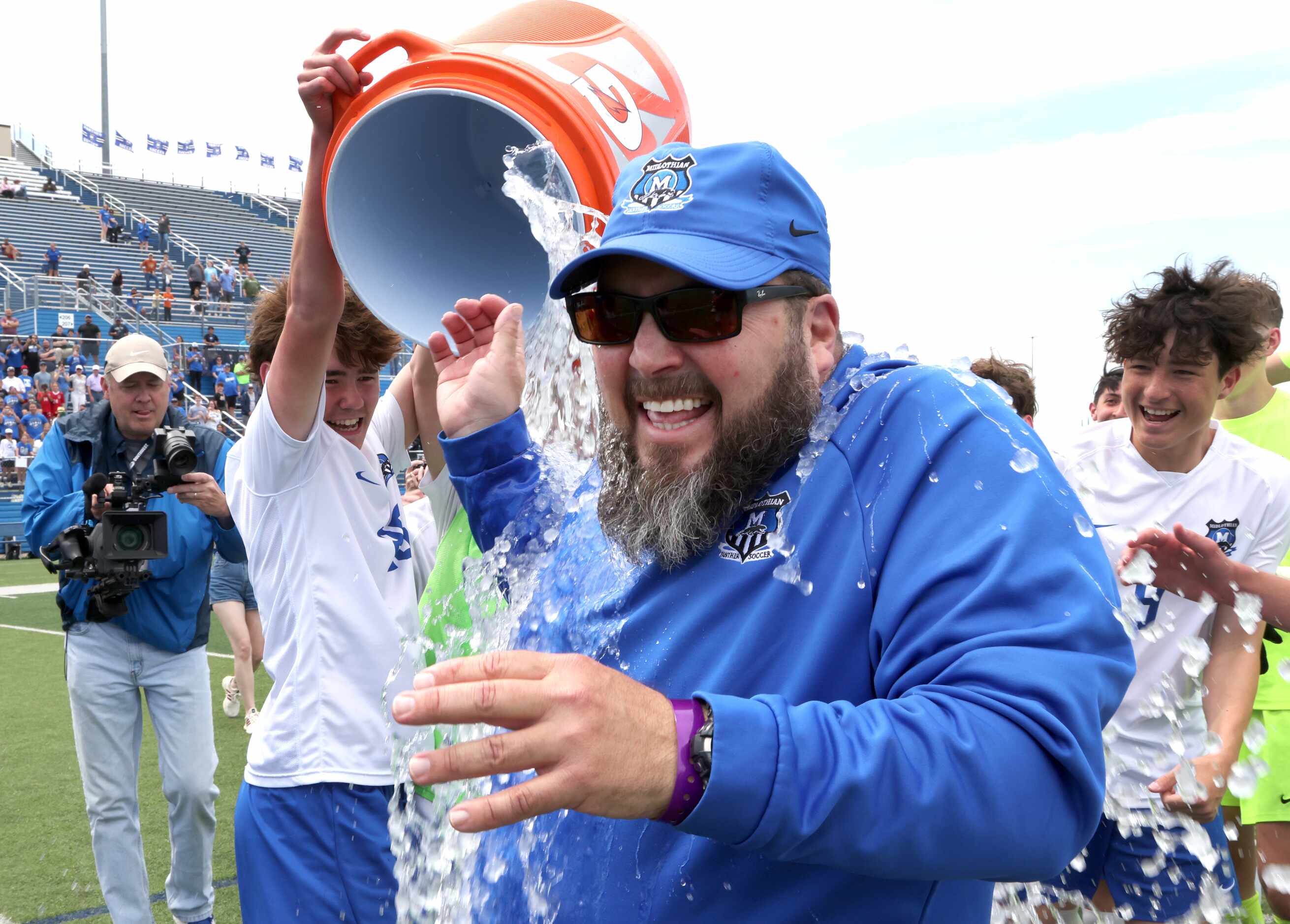  Midlothian head coach Austin Guest catches an ice and water dousing from his players...