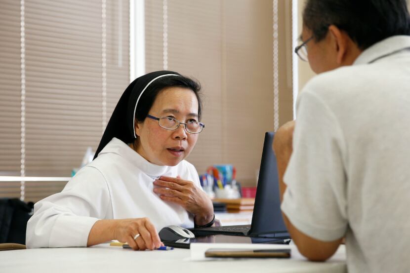 Sister Theresa Mai helps John Hoang of Houston, who was looking for more information about...