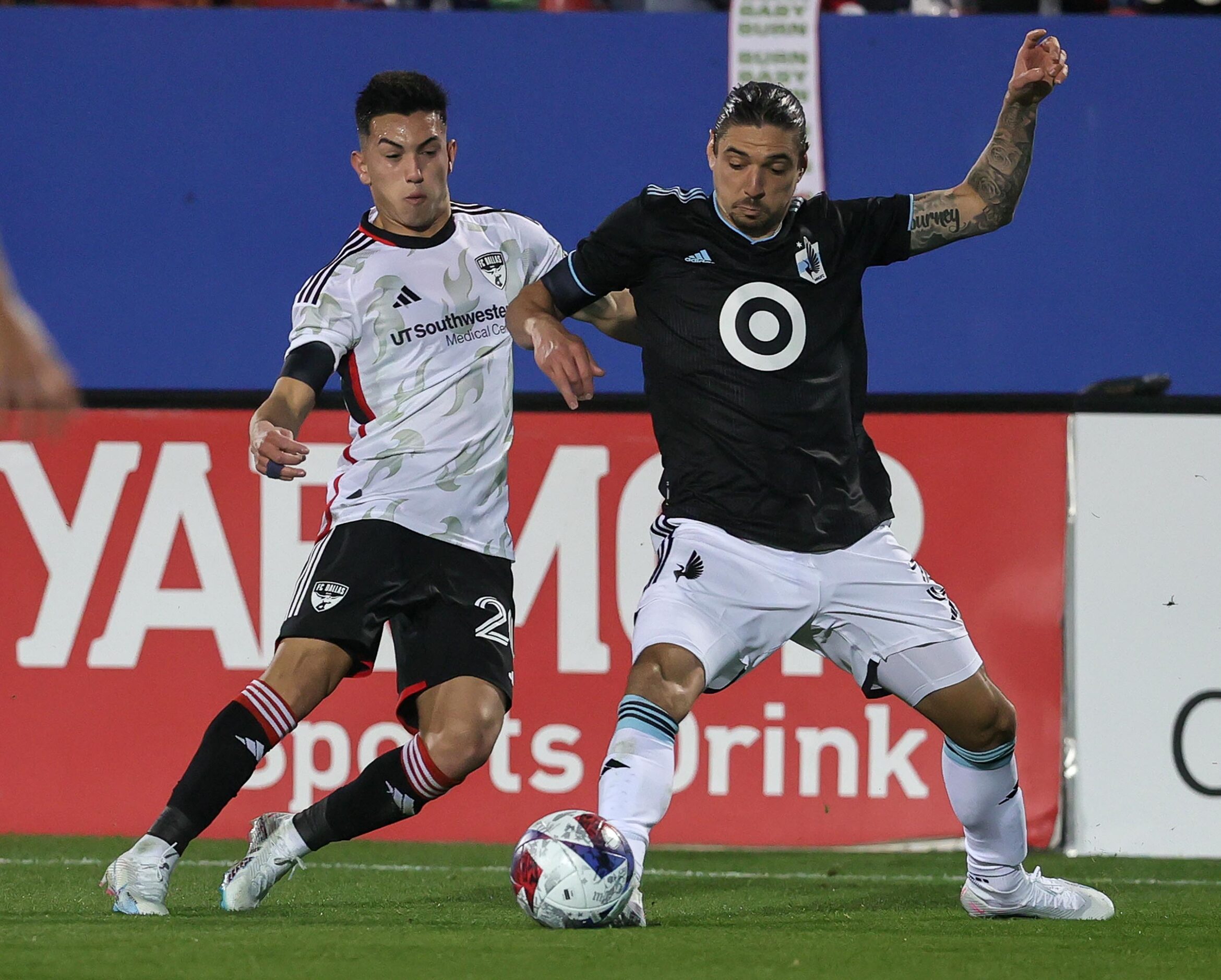 Minnesota United defender Zarek Valentin, (right) tries to control the ball against FC...