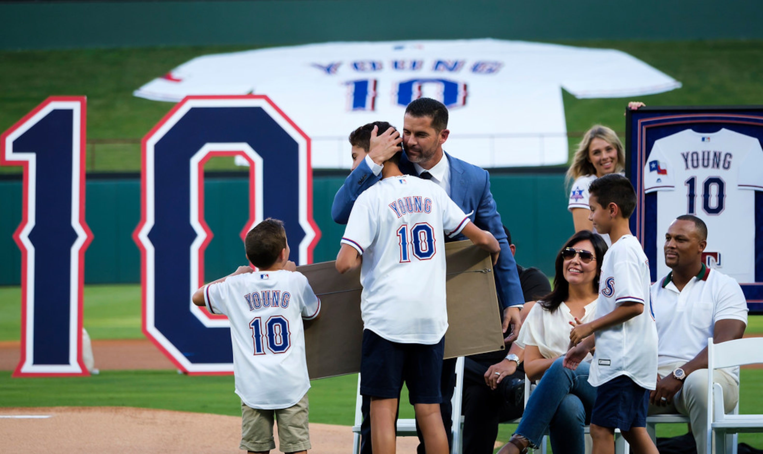 Michael Young hugs his son Mateo, 14, during ceremonies to retire Young's No. 10 before a...