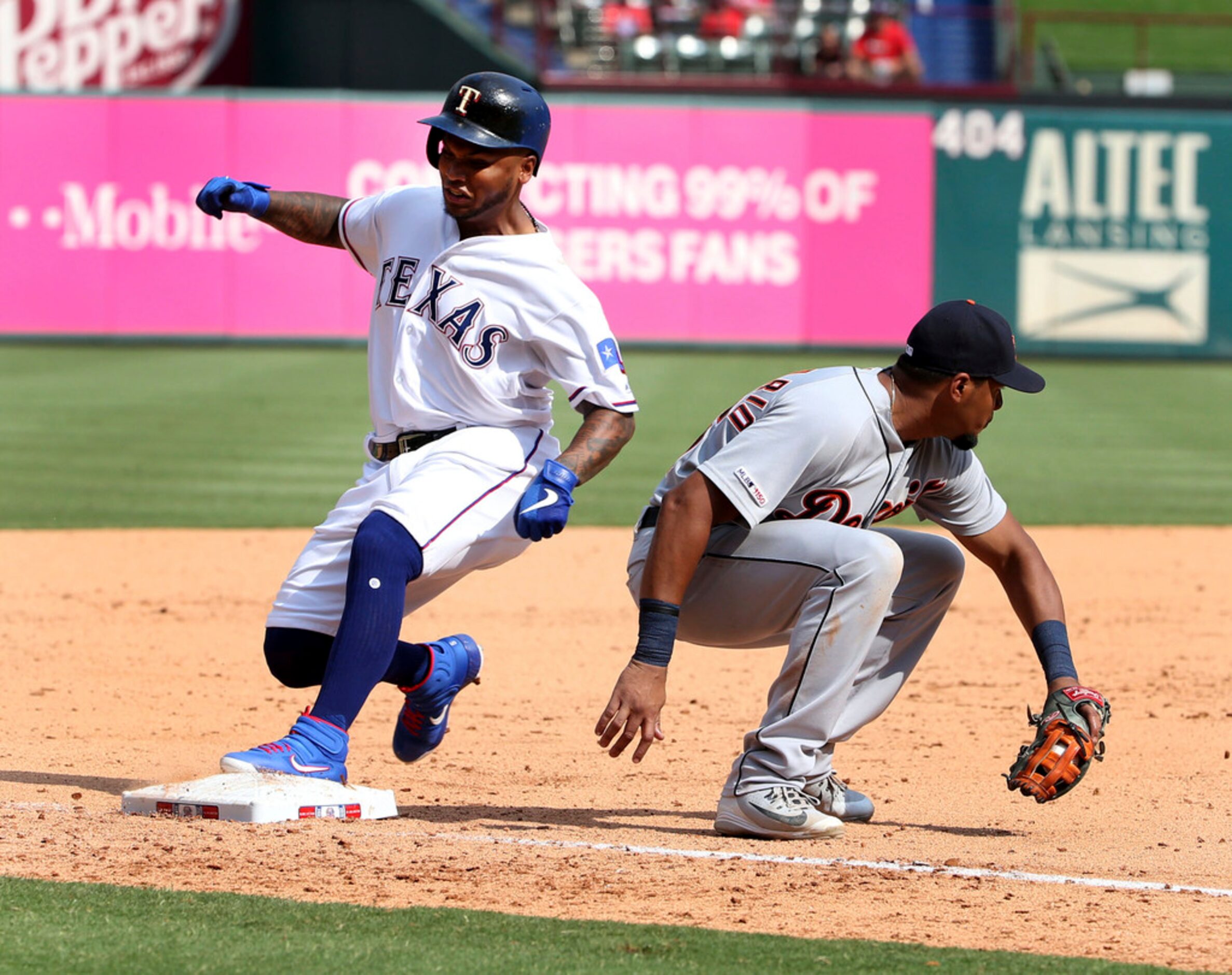 Texas Rangers Willie Calhoun, left, gets to third in front of Detroit Tigers third baseman...