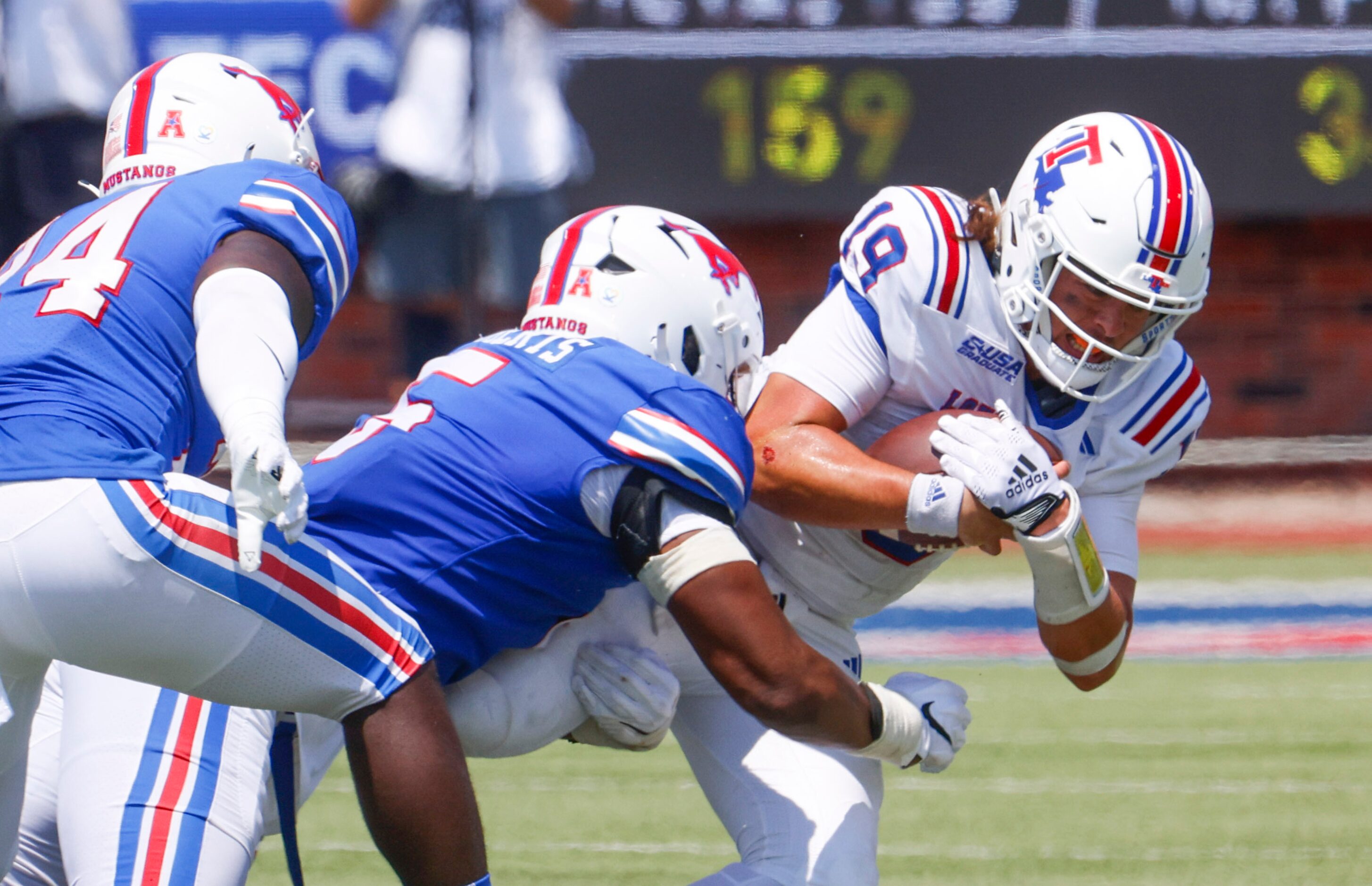 Southern Methodist defensive end Elijah Roberts (center) sacks Louisiana Tech quarterback...