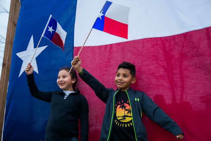 Gianna Bocanegra and Chris Madrid pose for photos with Texas flags at TexFest in downtown...