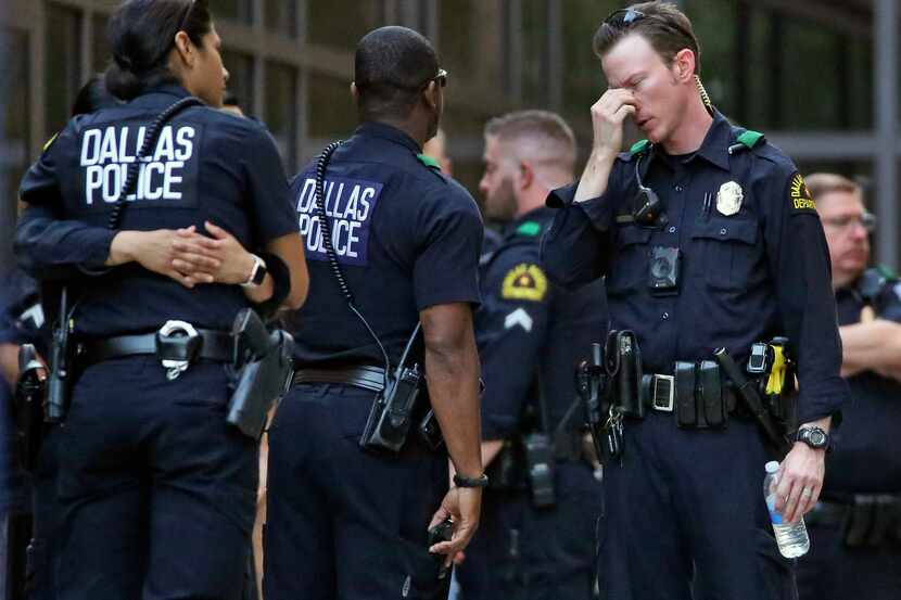 Dallas police officers waited outside the entrance of the emergency room at Texas Health...