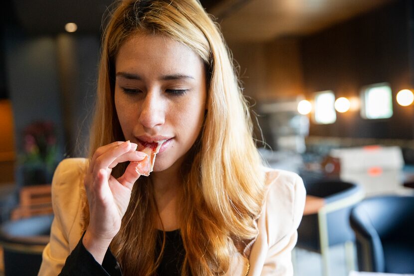 Hostess Helsy Almaguer (both cq) tries the Jamón de Cebo de Campo Ibérico at the new jamón...