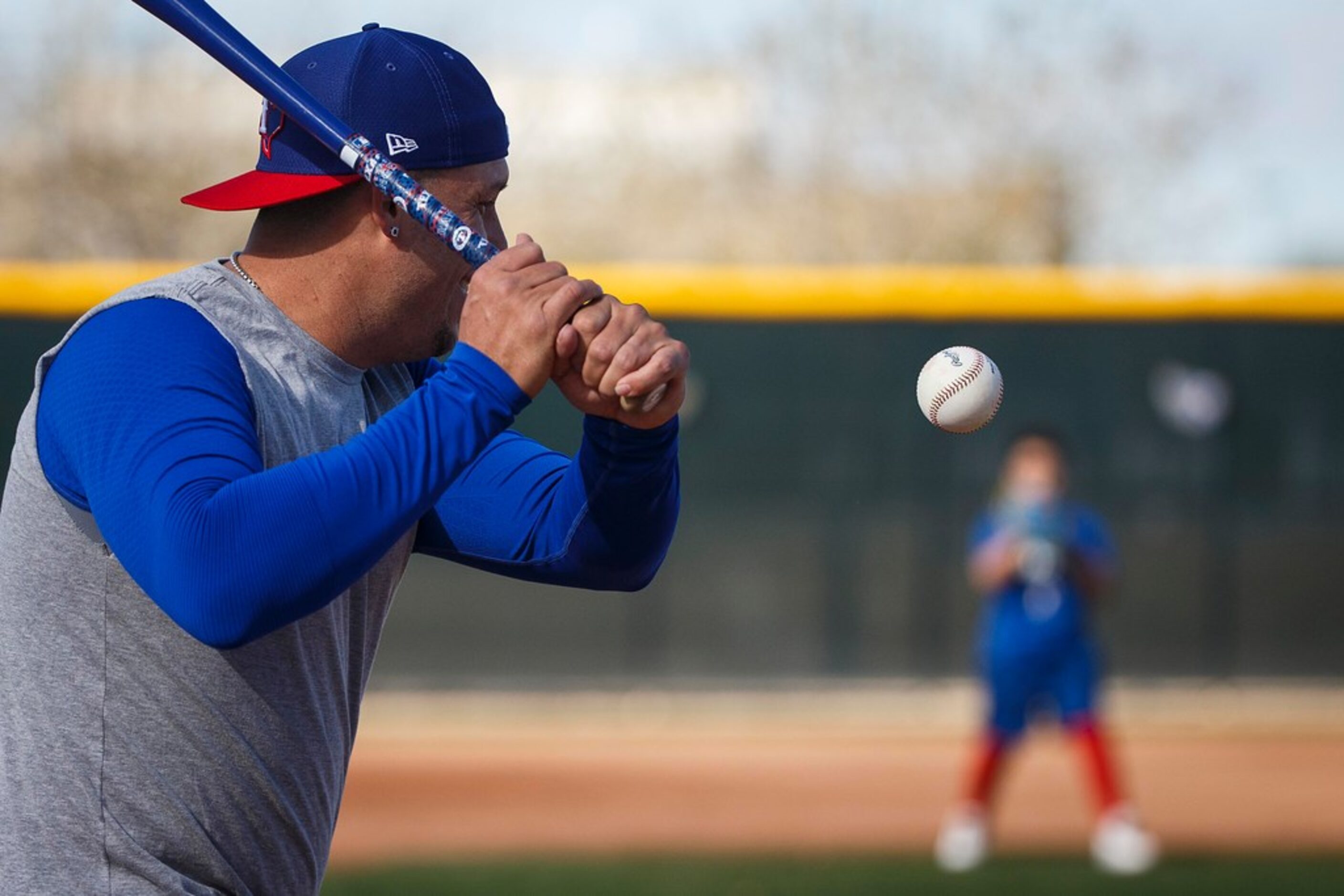 Texas Rangers infielder Asdrubal Cabrera hits grounders to his son Meyer before a spring...