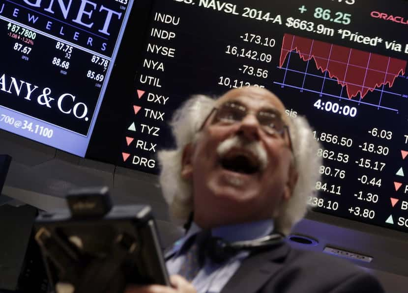 Trader Peter Tuchman watches a screen above the floor of the floor of the New York Stock...