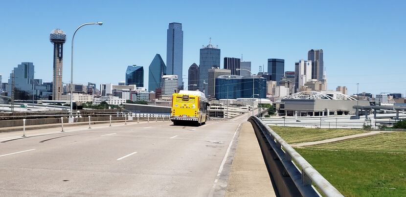 Yellow bus driving toward downtown Dallas
