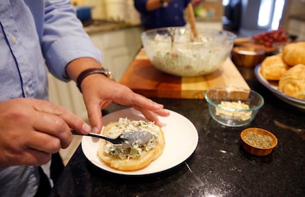 Wesley Loon puts "best-ever chicken salad" on a croissant. His husband Kris Longwell created...