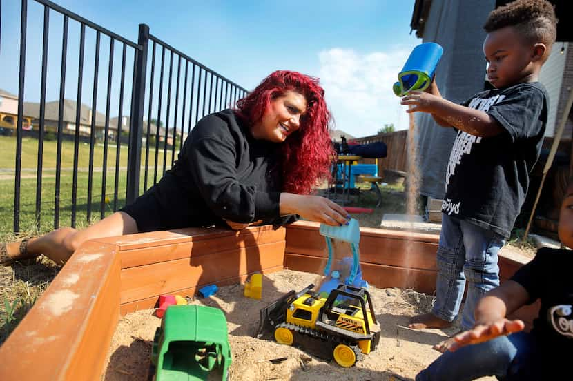 Jantzen Verastique plays with her children Jonah (standing), 3, and Lukah, 2, at their home. 