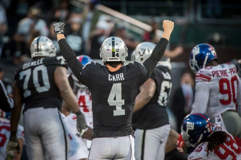 Oakland Raiders quarterback Derek Carr (4) celebrates his team's 24-17 victory against the...