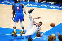 Dallas Mavericks guard Luka Doncic (77) is fouled by Oklahoma City Thunder guard Luguentz...