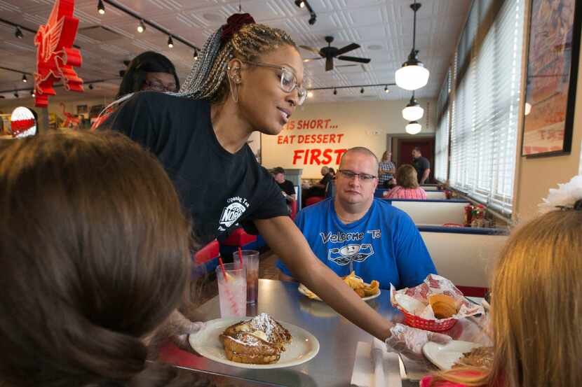 Waitress Morgan Butler delivers food to a table during the pre-opening weekend, at the new...