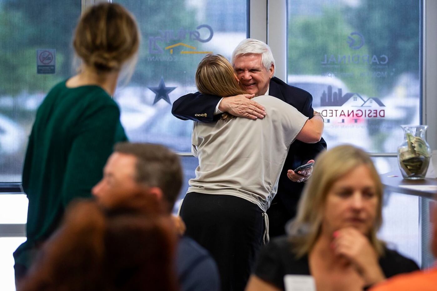 CFO George French hugs Traci Benson as he arrives for a Century 21 Judge Fite happy hour in...