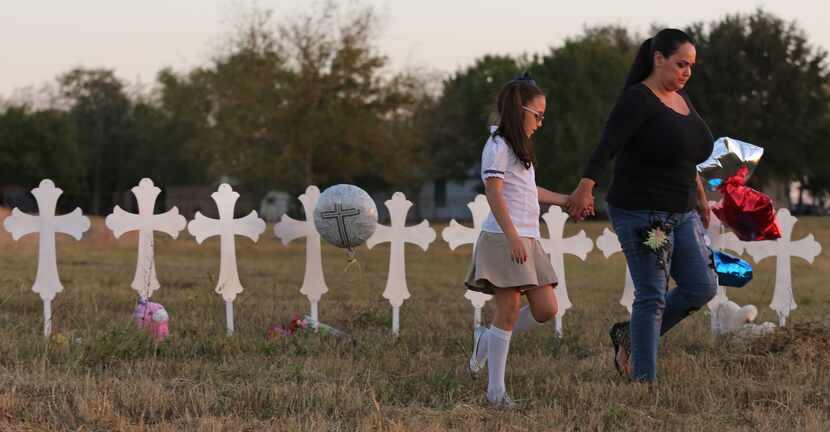 Eight-year-old Heather Cooper and her mother Meredith Cooper of San Antonio walk away after...