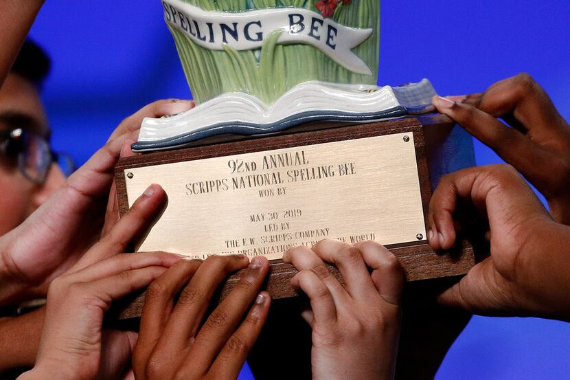 Eight co-champions carry a trophy after winning the 2019 Scripps National Spelling Bee.