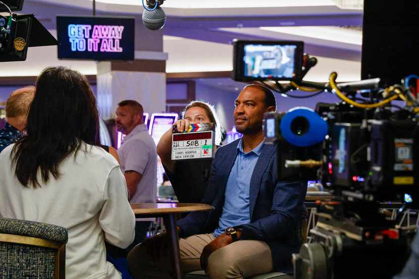 A crew member holds a clapperboard in front of former Dallas Cowboys player Darren Woodson...