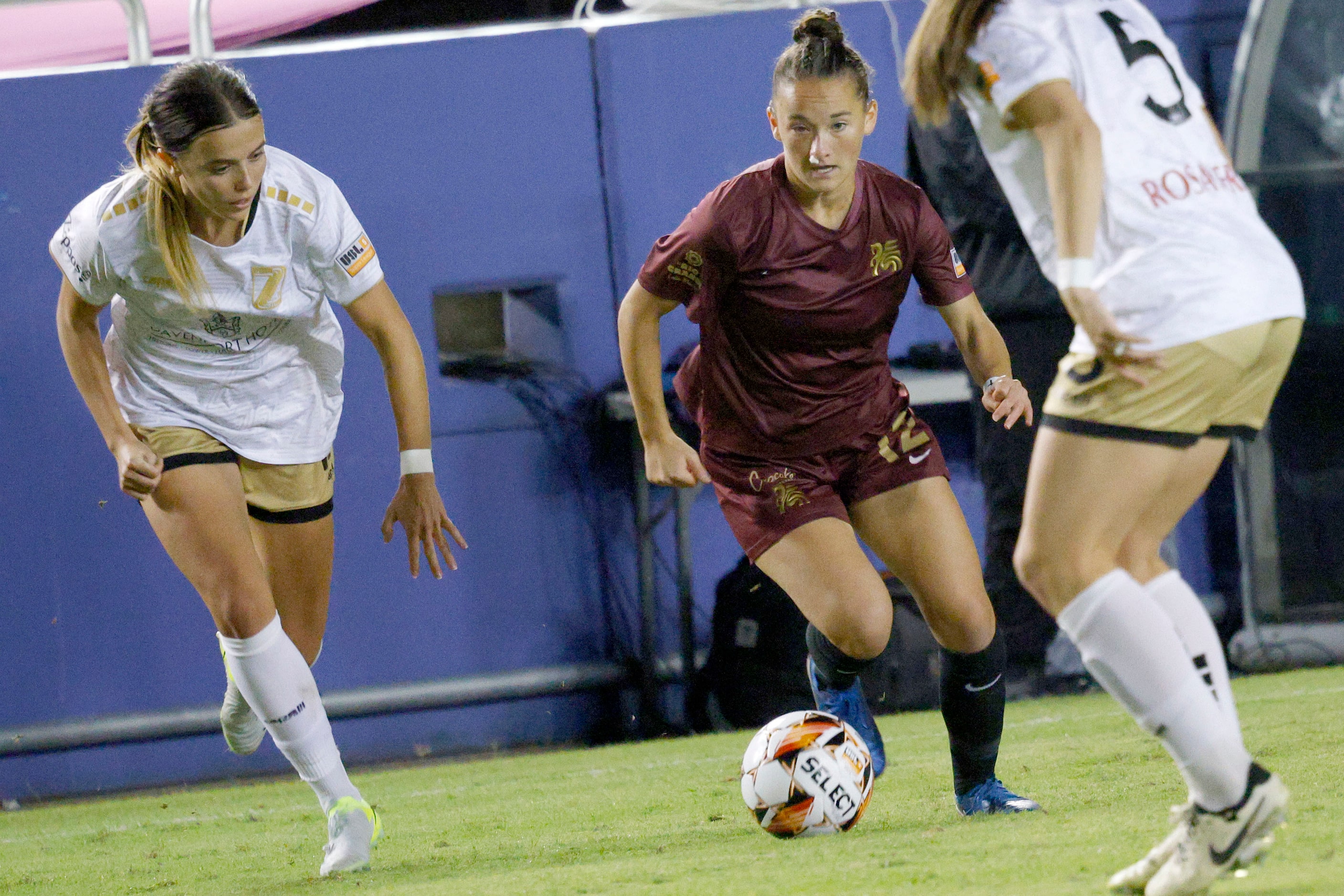 Dallas Trinity forward Sealey Strawn (12), center, controls the ball against Spokane Zephyr...